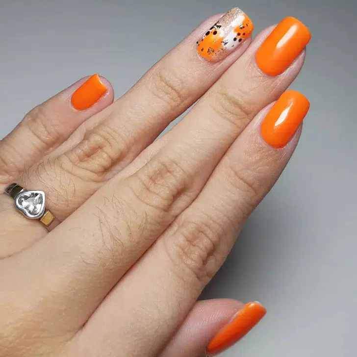 Глянцевый оранжевый маникюр с акцентным ногтем с блестками