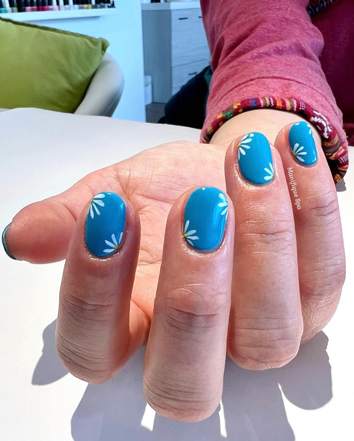 Голубой маникюр с ромашками на коротких овальных ногтях