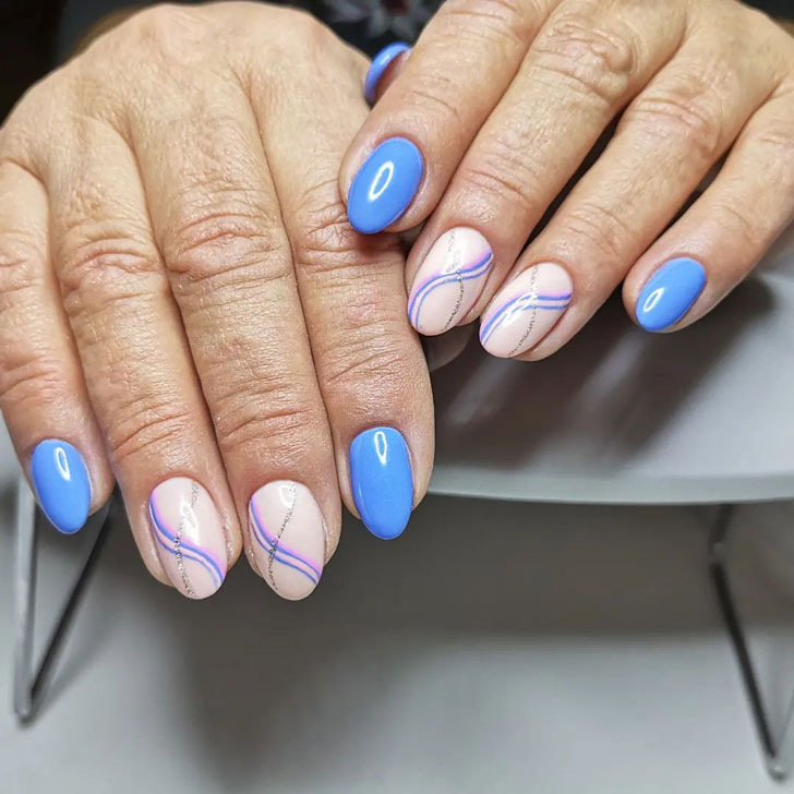 Голубой маникюр с волнистыми линиями на овальных ногтях