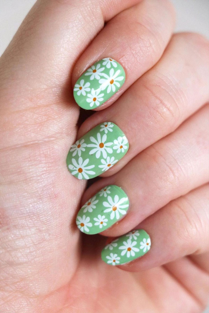 Зеленый маникюр с белыми ромашками на овальных ногтях