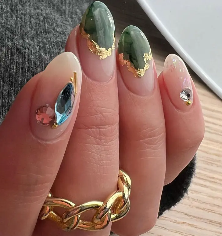Зеленый маникюр со стразами и золотой фольгой на овальных ногтях
