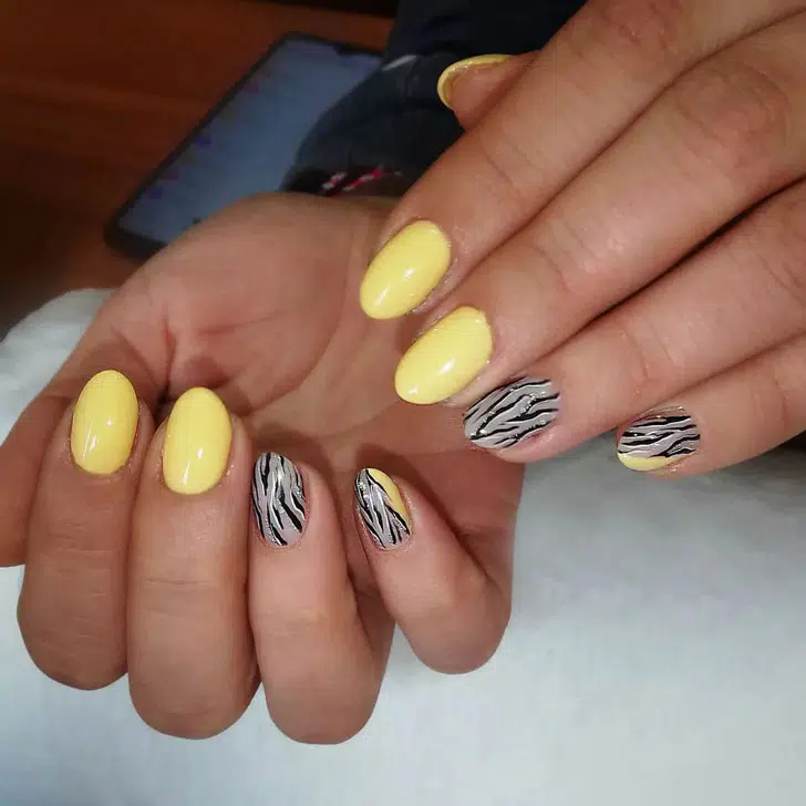 Желтый маникюр с животным принтом на овальных ногтях средней длины