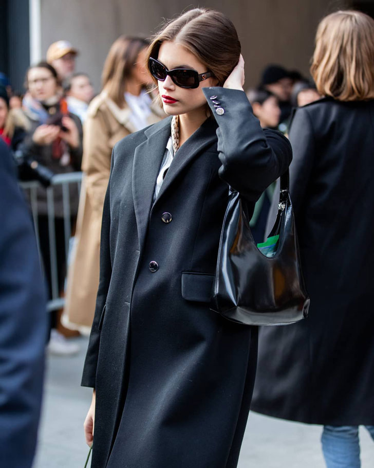 Девушка в черном пальто оверсайз и мягкой сумочкой на плече