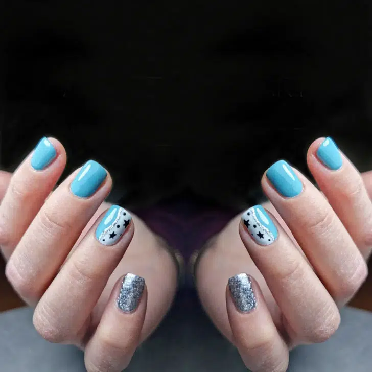 Голубой маникюр с блестками и черными звездами на коротких ногтях