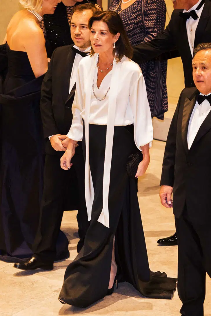 Каролина Монакская в длинной черной юбке с разрезом и шелковой белой блузке