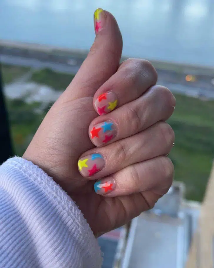 Маникюр с яркими разноцветными звездами на коротких натуральных ногтях
