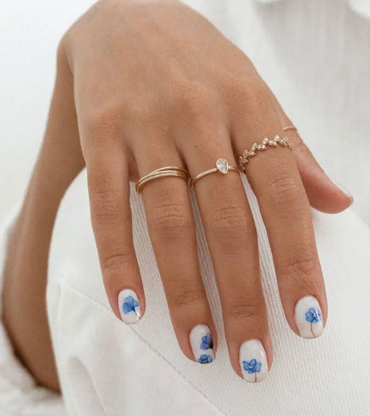 Белый маникюр с голубыми акварельными цветами на коротких ногтях