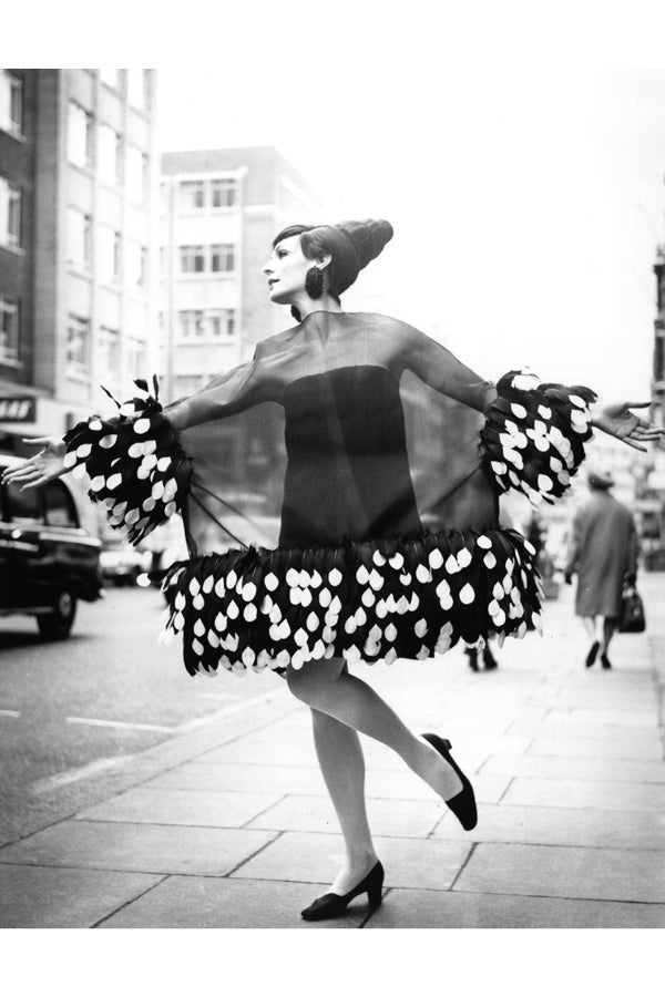 Девушка в черном мини платье с легкой накидкой с перьями 1967 год