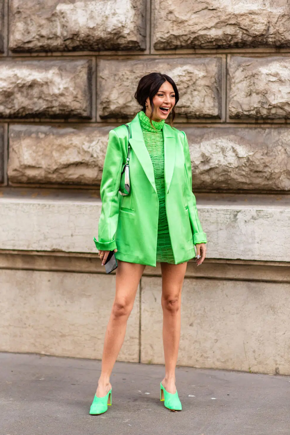 Девушка в зеленом мини платье, пиджаке оверсайз и сабо на каблуке