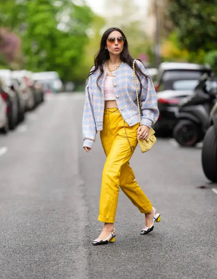 Девушка в желтых кожаных брюках, твидовом блейзере и туфлях на низком каблуке