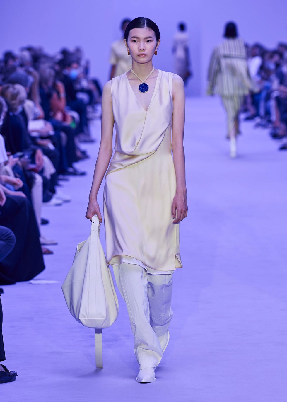 Модель в шелковом платье молочного цвета от Jil Sander