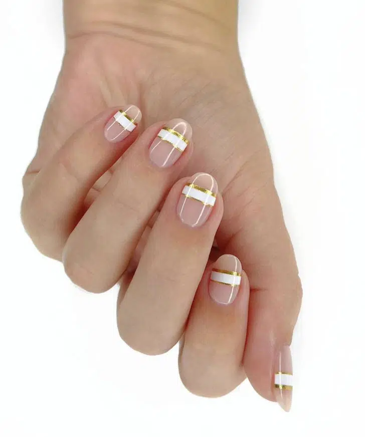 Натуральный маникюр с белой горизонтальной и золотой полосой на овальных ногтях