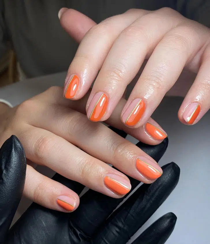 Оранжевый маникюр с золотой линией по центру на овальных ногтях 