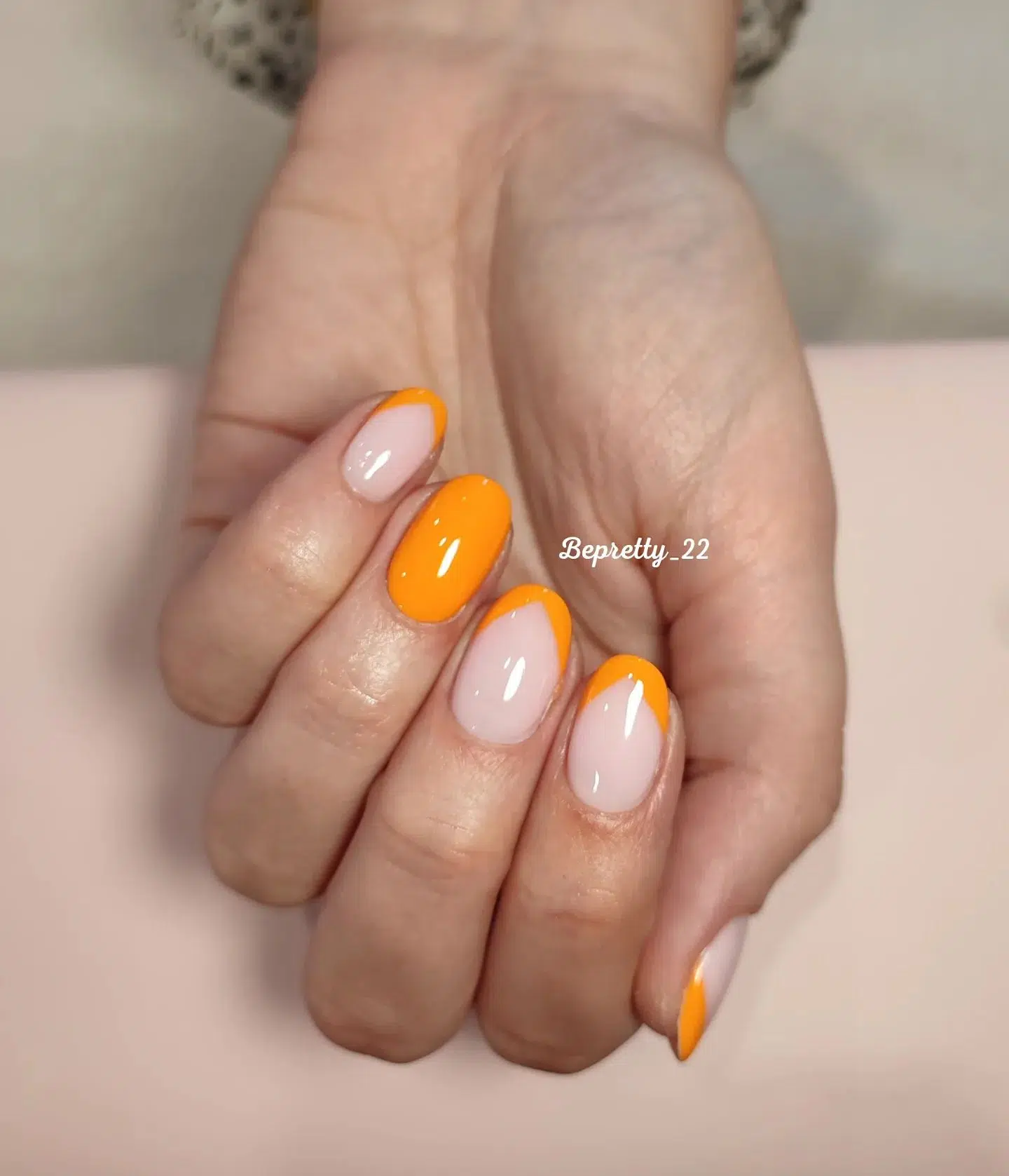 Оранжевый треугольный френч на овальных ногтях средней длины