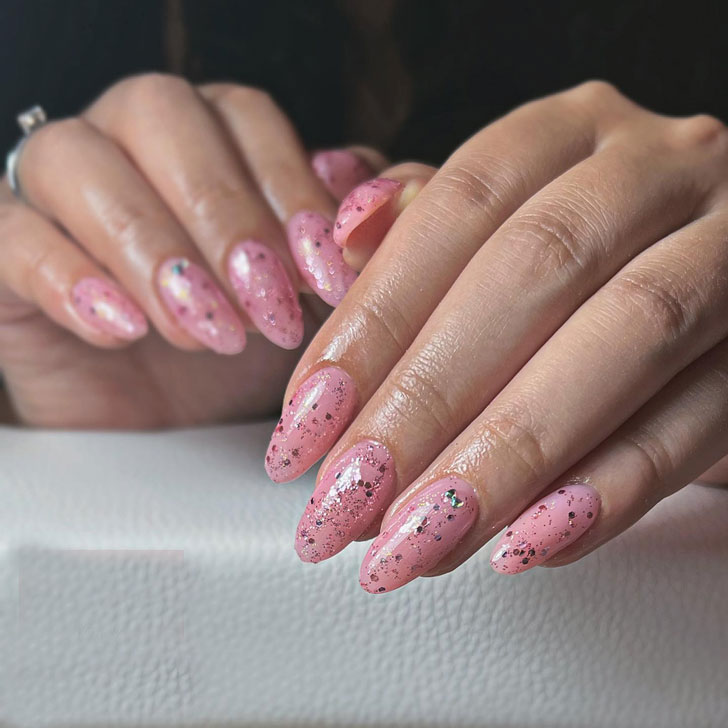 Светло розовый маникюр с блестками на длинных ухоженных ногтях
