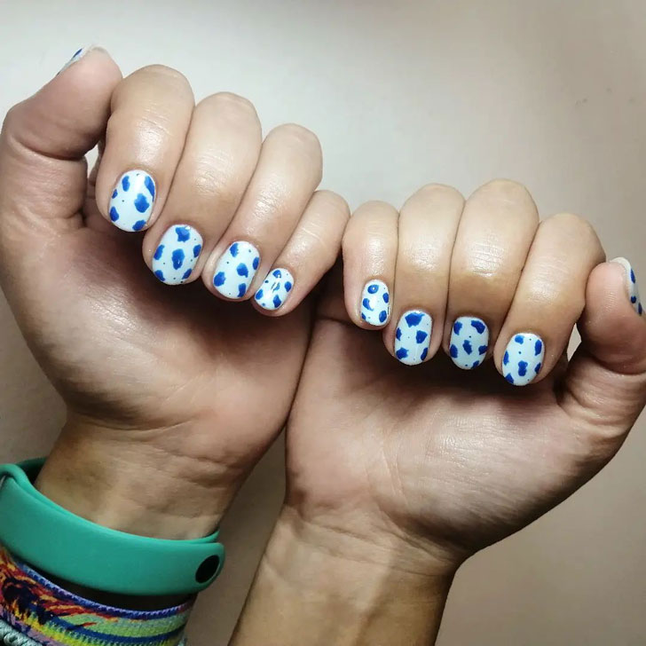 Белый маникюр с синим коровьим принтом на коротких овальных ногтях