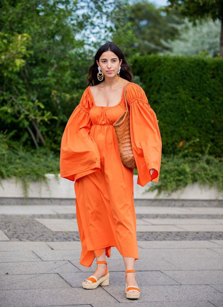 Девушка в оранжевом платье с широкими рукавами и эспадрильях на платформе с ремешками