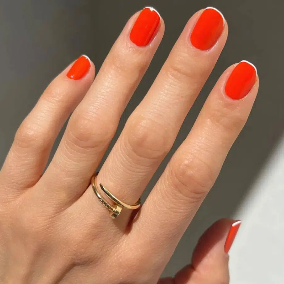 Красный маникюр с тонкой белой линией на коротких натуральных ногтях