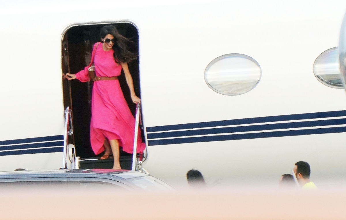 Амаль Клуни в платье цвета фуксии спускается с самолета
