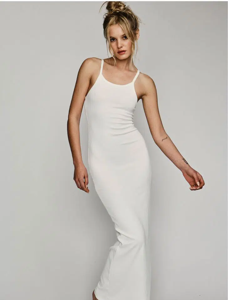 Модель в белом облегающем платье макси на бретельках