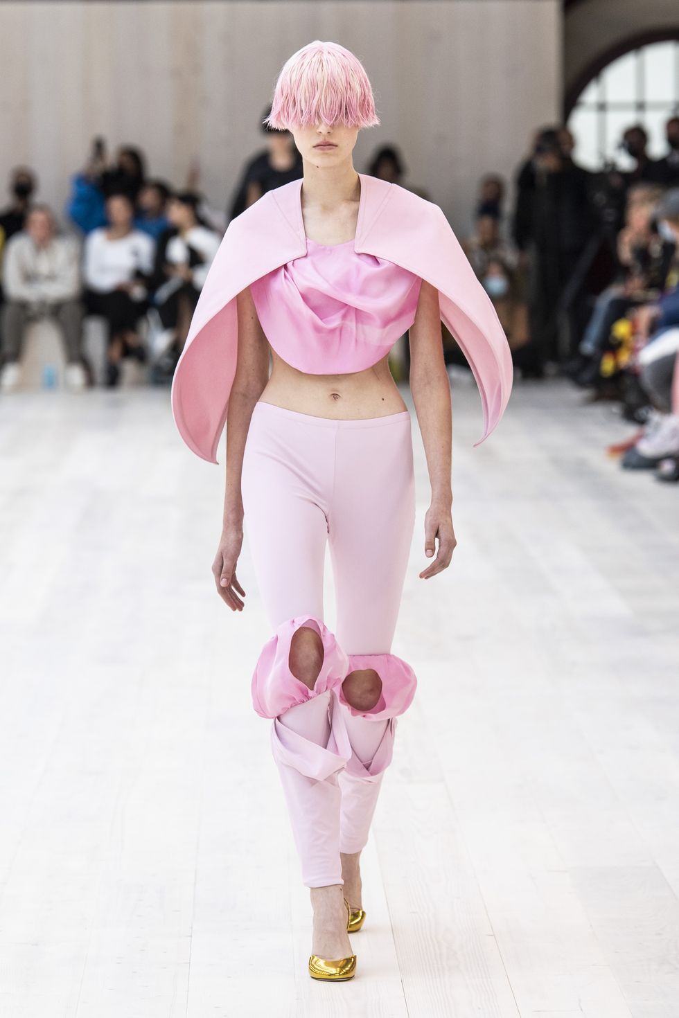 Модель в розовом коротком топе и узких штанах с дырками от Loewe