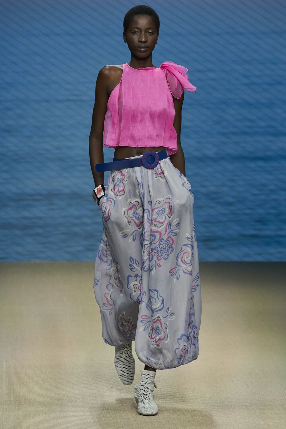 Модель в розовом шелковом топе и просторных штанах с цветочным принтом от Giorgio Armani