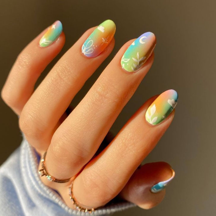 Разноцветный маникюр омбре с белым принтом на овальных ногтях