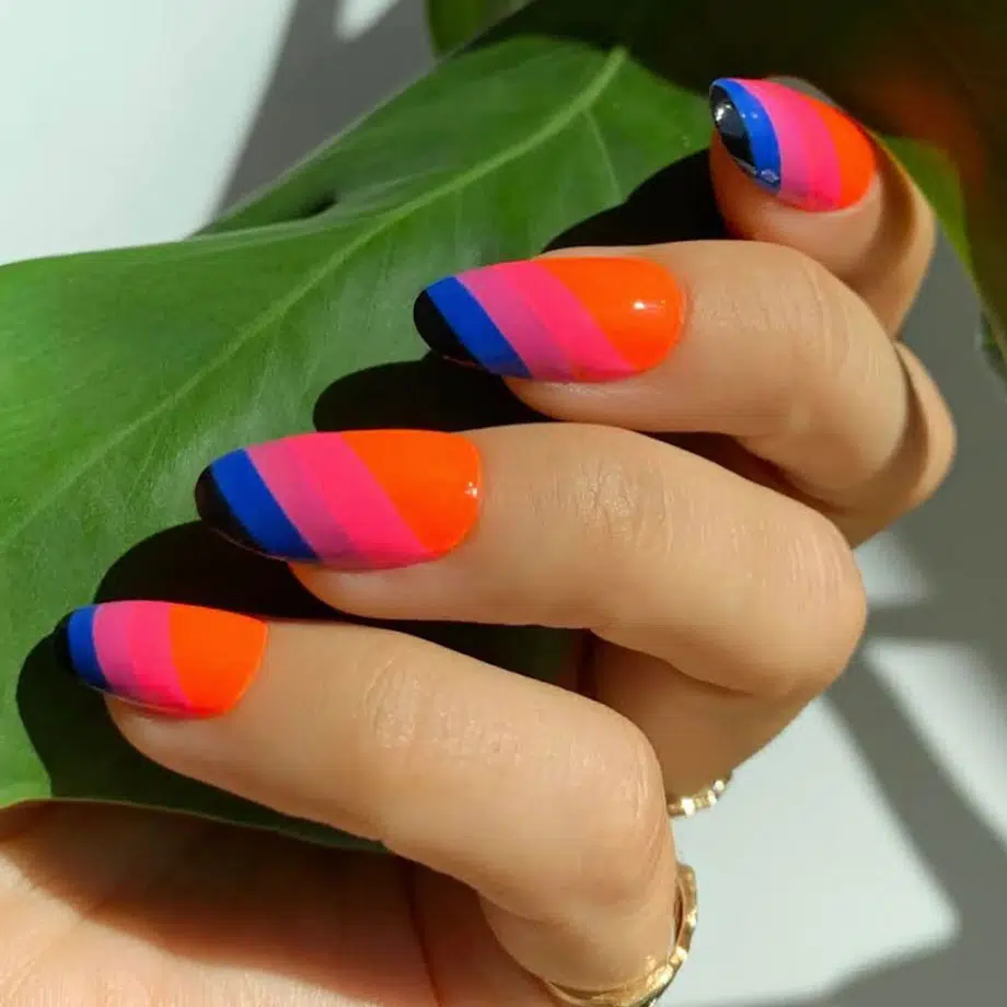 Яркий разноцветный маникюр в полоску на овальных ногтях средней длины