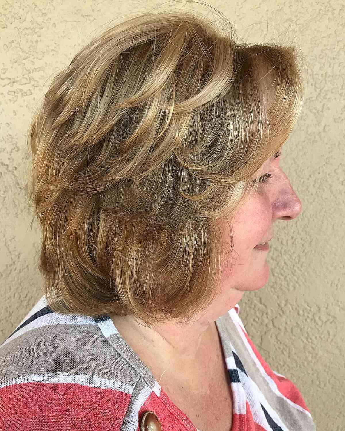 Женщина с пернатой стрижкой на светлых густых волосах