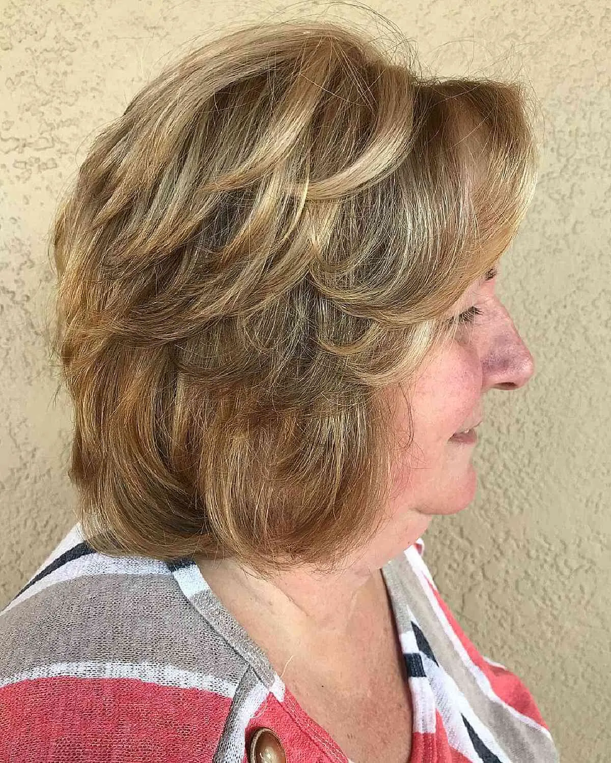 Женщина с пернатой стрижкой на светлых густых волосах