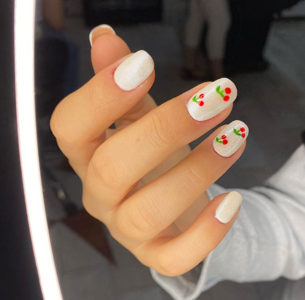Белый жемчужный маникюр с ягодным принтом на квадратных ногтях средней длины