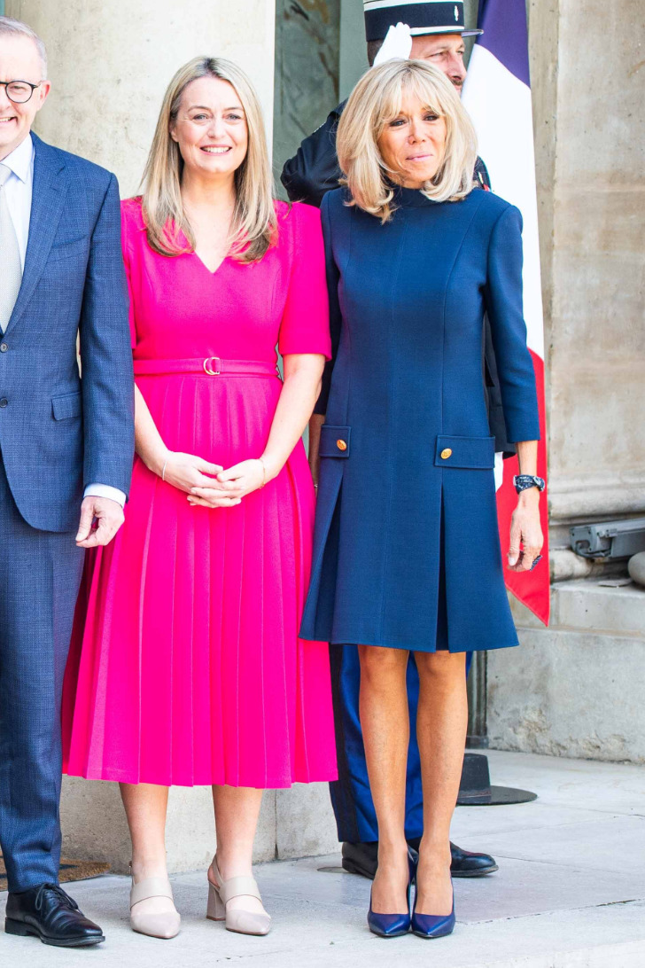 Брижит Макрон в синем платье и гостья в розовом платье в Елисейском дворце