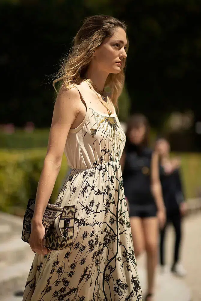 Девушка в светлом платье миди с цветочным принтом и растрепанной прической