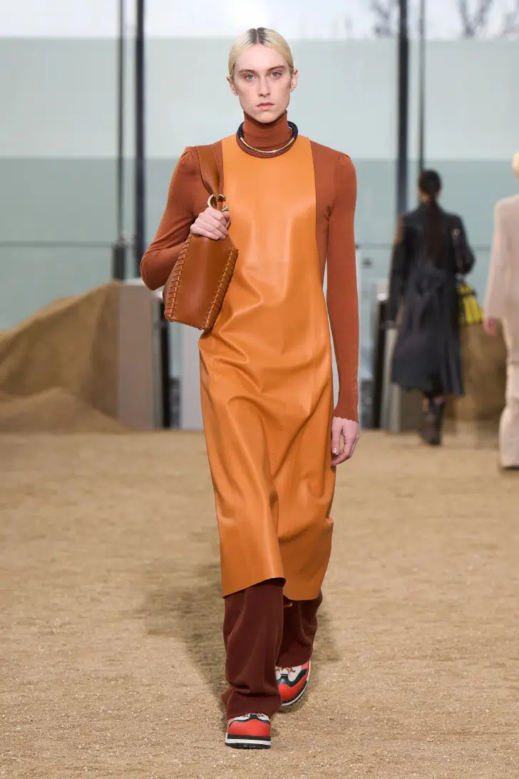 Модель в оранжевом платье миди поверх брюк от Сhloe