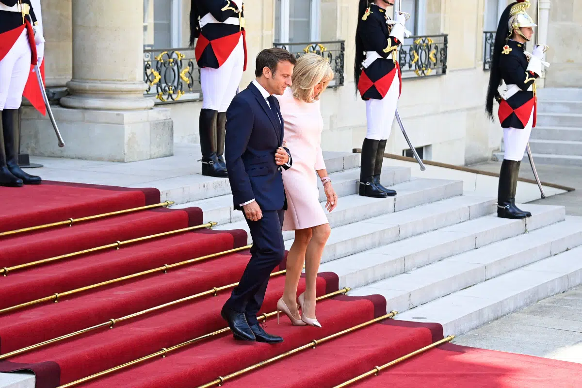 Брижит Макрон в персиковом коротком платье спускается вместе с мужем по красной дорожке