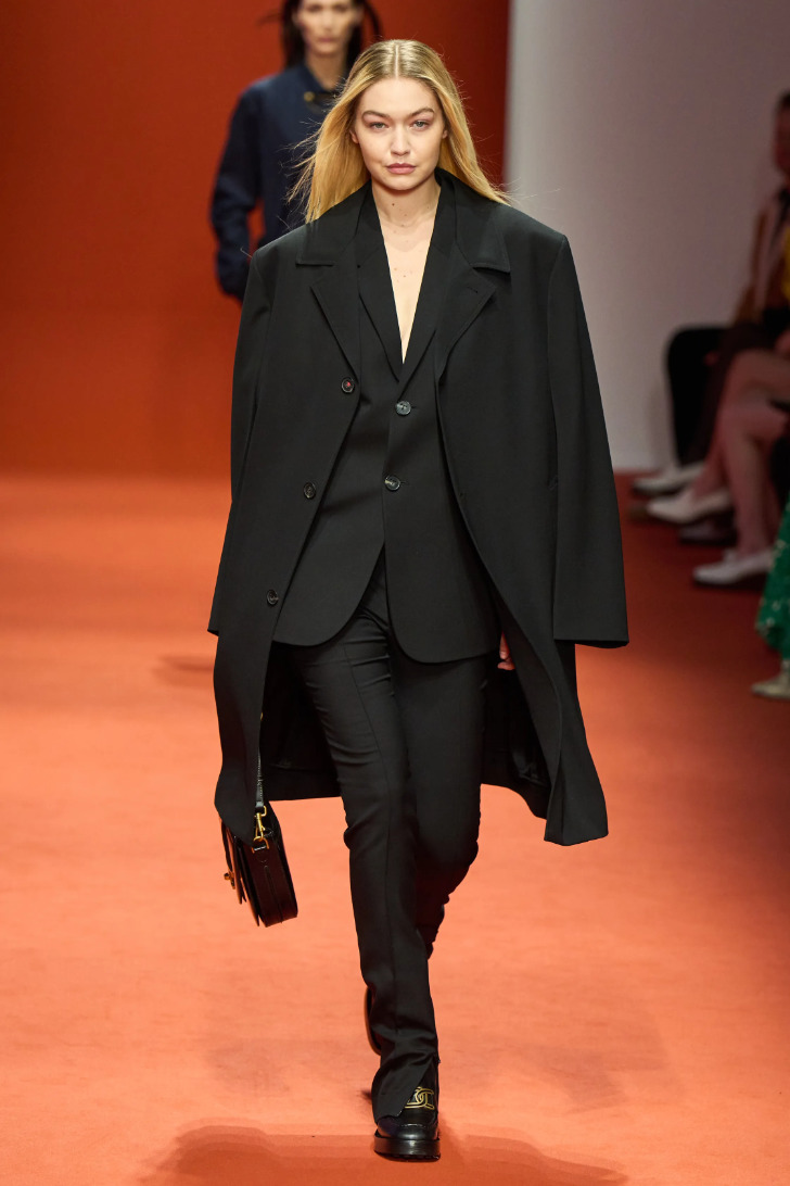 Модель в черном деловом костюме с пальто от Тods