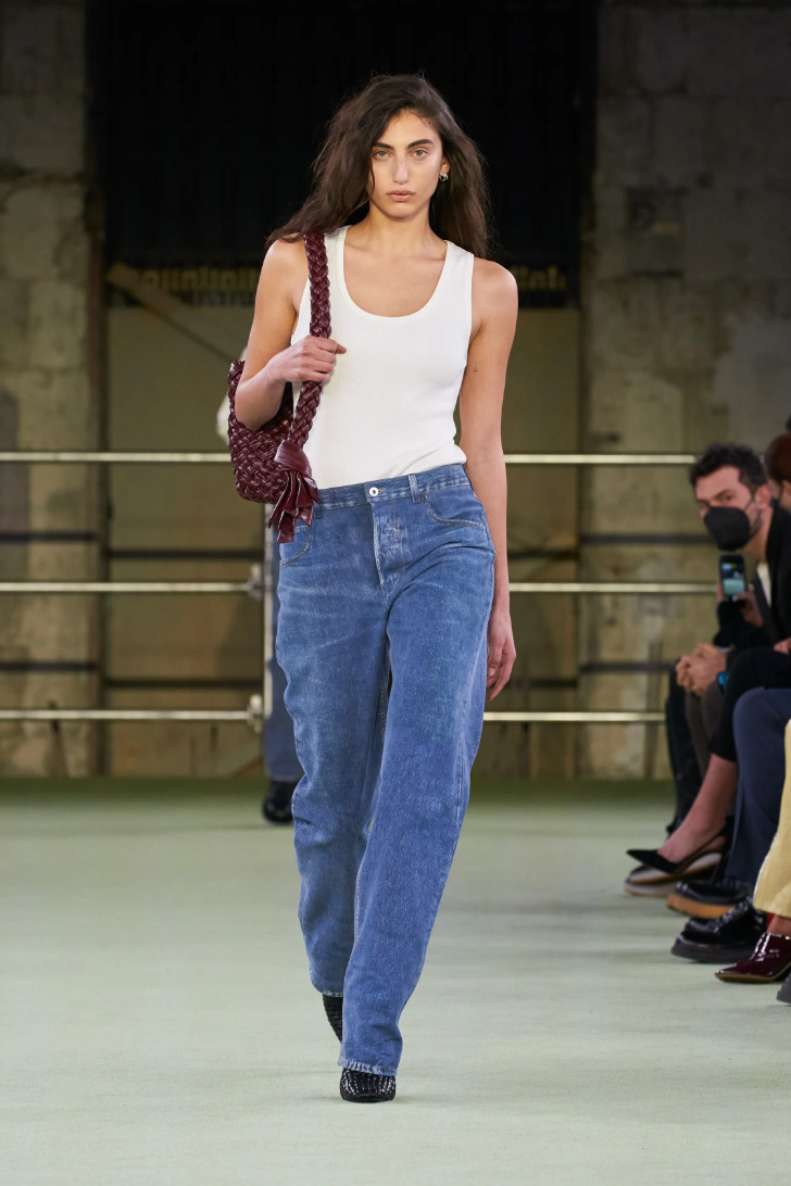 Модель в мешковатых джинсах и простой белой майке от Bottega Veneta