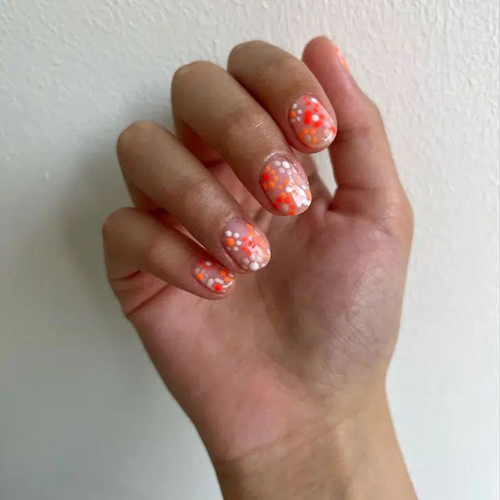 Оранжевый маникюр с цветами и точками на коротких овальных ногтях