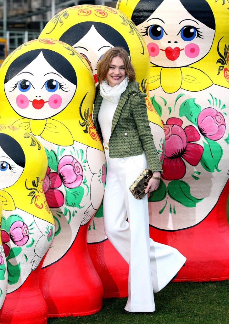 Наталья Водянова в белых расклешенных брюках, свитере и короткой куртке