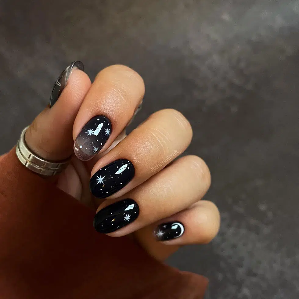 Черный маникюр с белыми звездочками на овальных ногтях средней длины