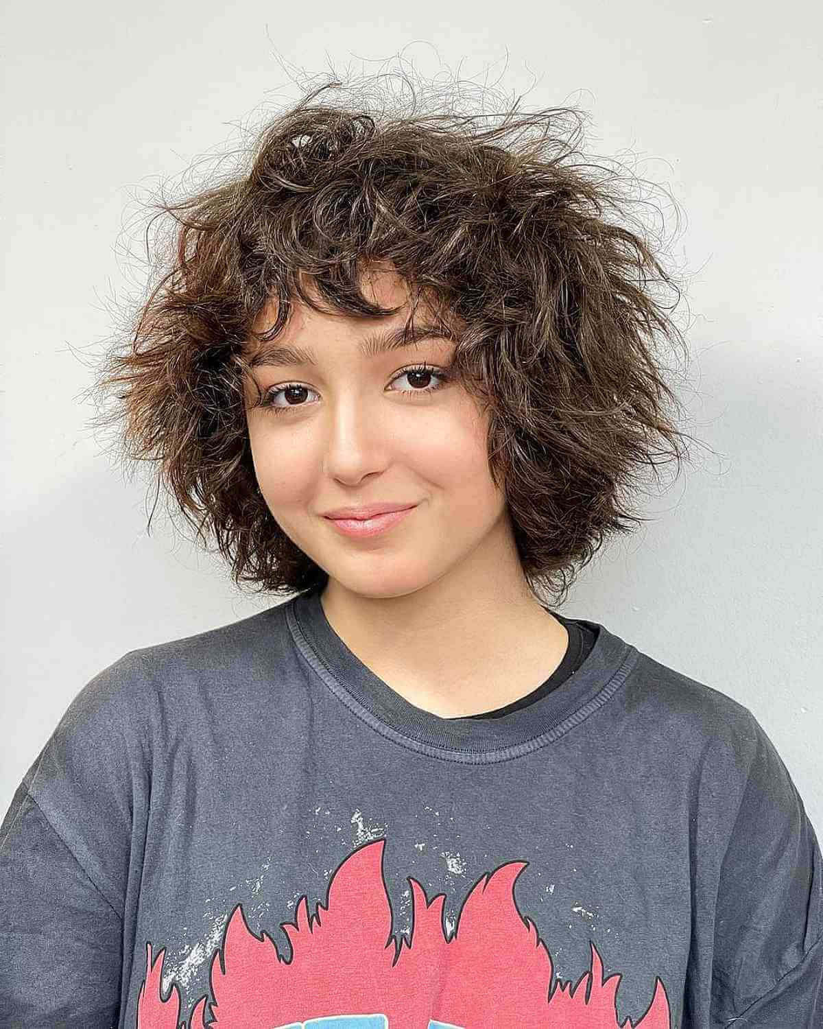 Девушка с многослойной лохматой стрижкой на натуральных густых волосах