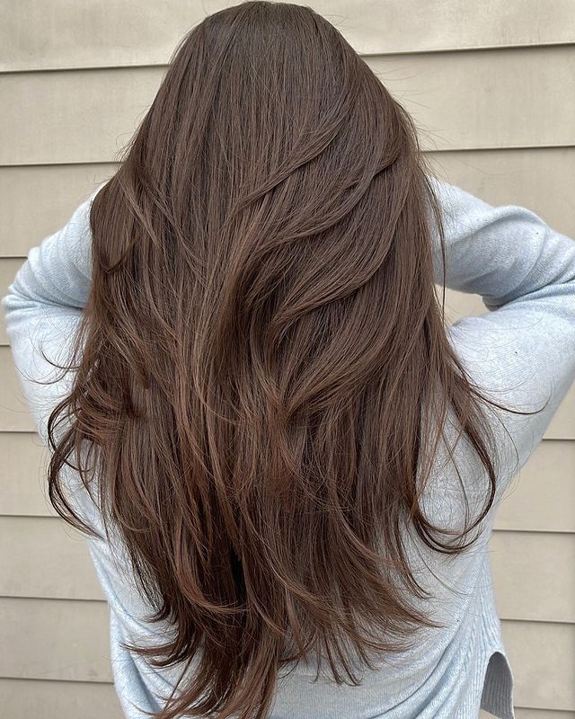 Девушка с многослойной стрижкой на натуральных густых волосах