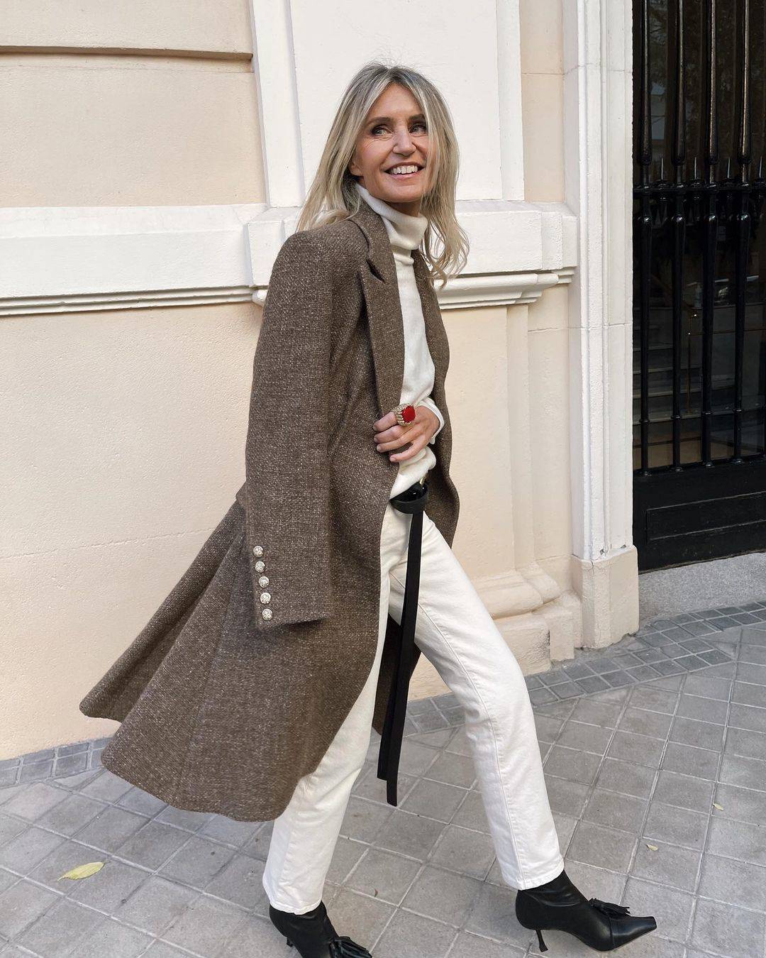 Патриция Казарини в белых джинсах, свитере и сером пальто