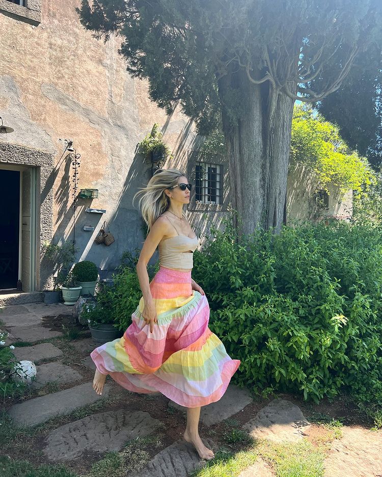Елена Сантарелли в разноцветной длинной юбке и простом топе