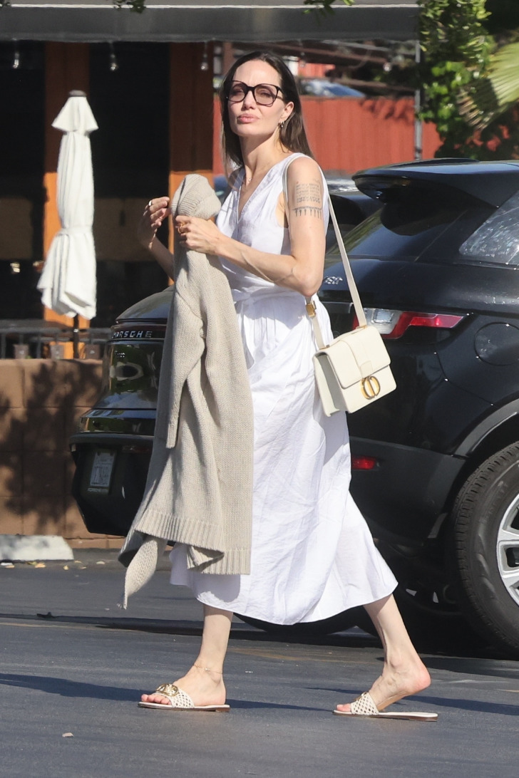 Анджелина Джоли в белом платье и модных бежевых сандалиях на плоской подошве