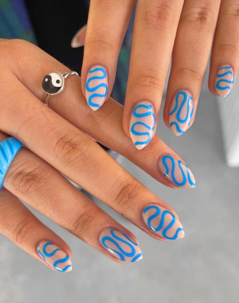 Натуральный маникюр с голубыми волнистыми линиями на острых ногтях средней длины