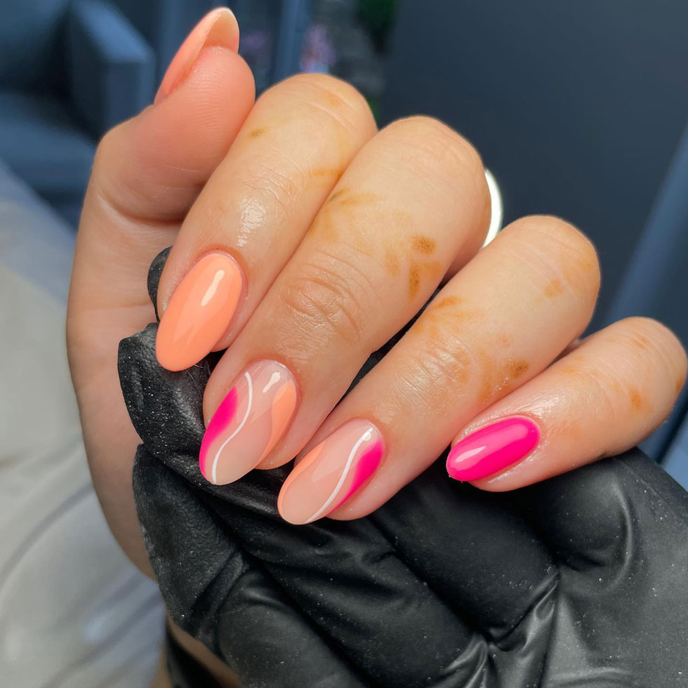 Розовый и персиковый маникюр с волнами на овальных ухоженных ногтях средней длины