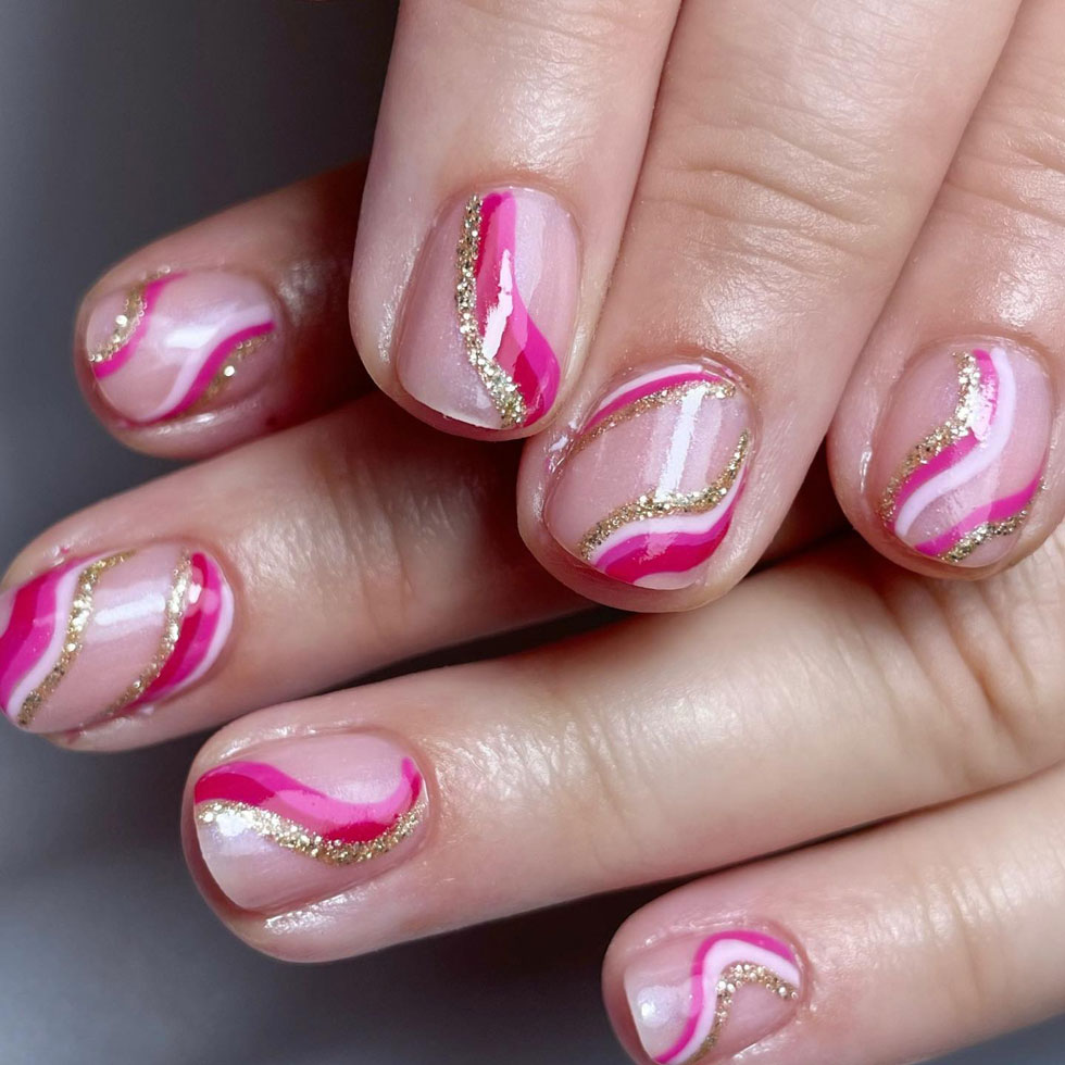 Яркий розовый маникюр с завитками и золотыми блестками на коротких ногтях