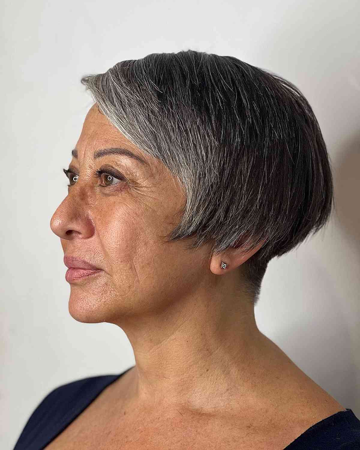 Женщина с короткой стрижкой боб с боковой челкой на седых волосах