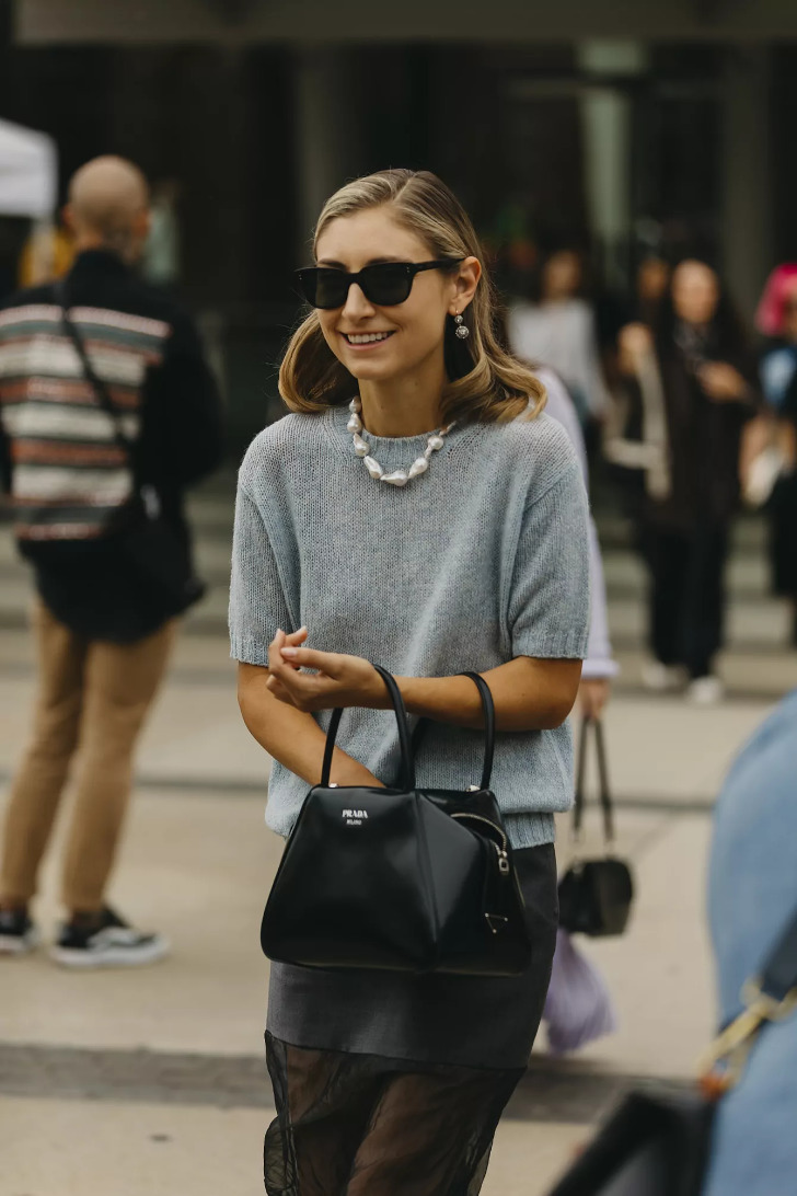 Девушка в узкой юбке, мягком вязаном свитере и сумкой Prada